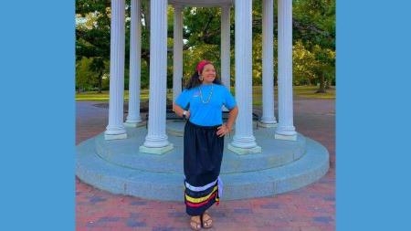 Lyric Locklear posing for a photo in front of the Old Well on the campus of UNC-Chapel Hill.